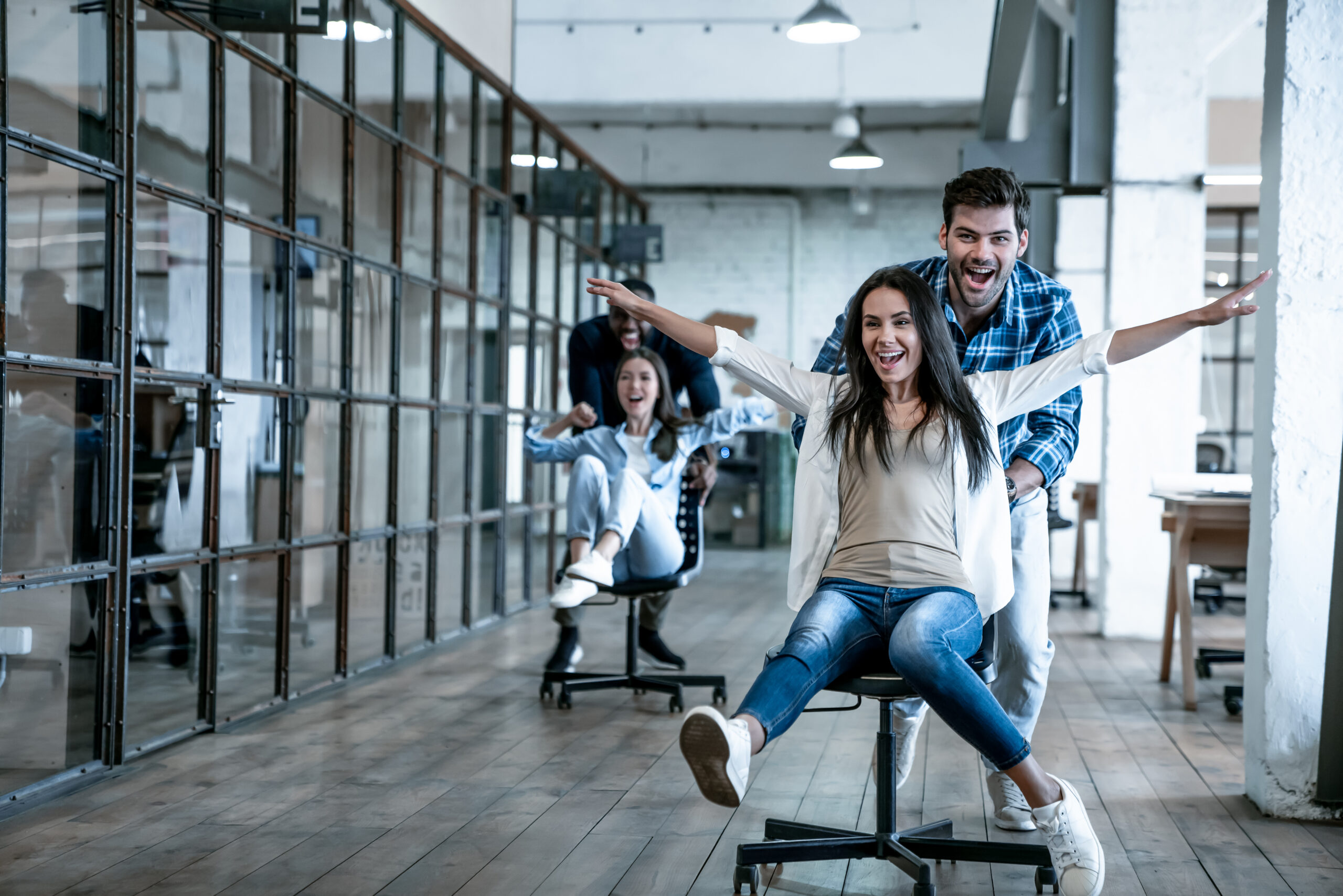 AdobeStock_301475558 Work hard play hard Four young cheerful business people